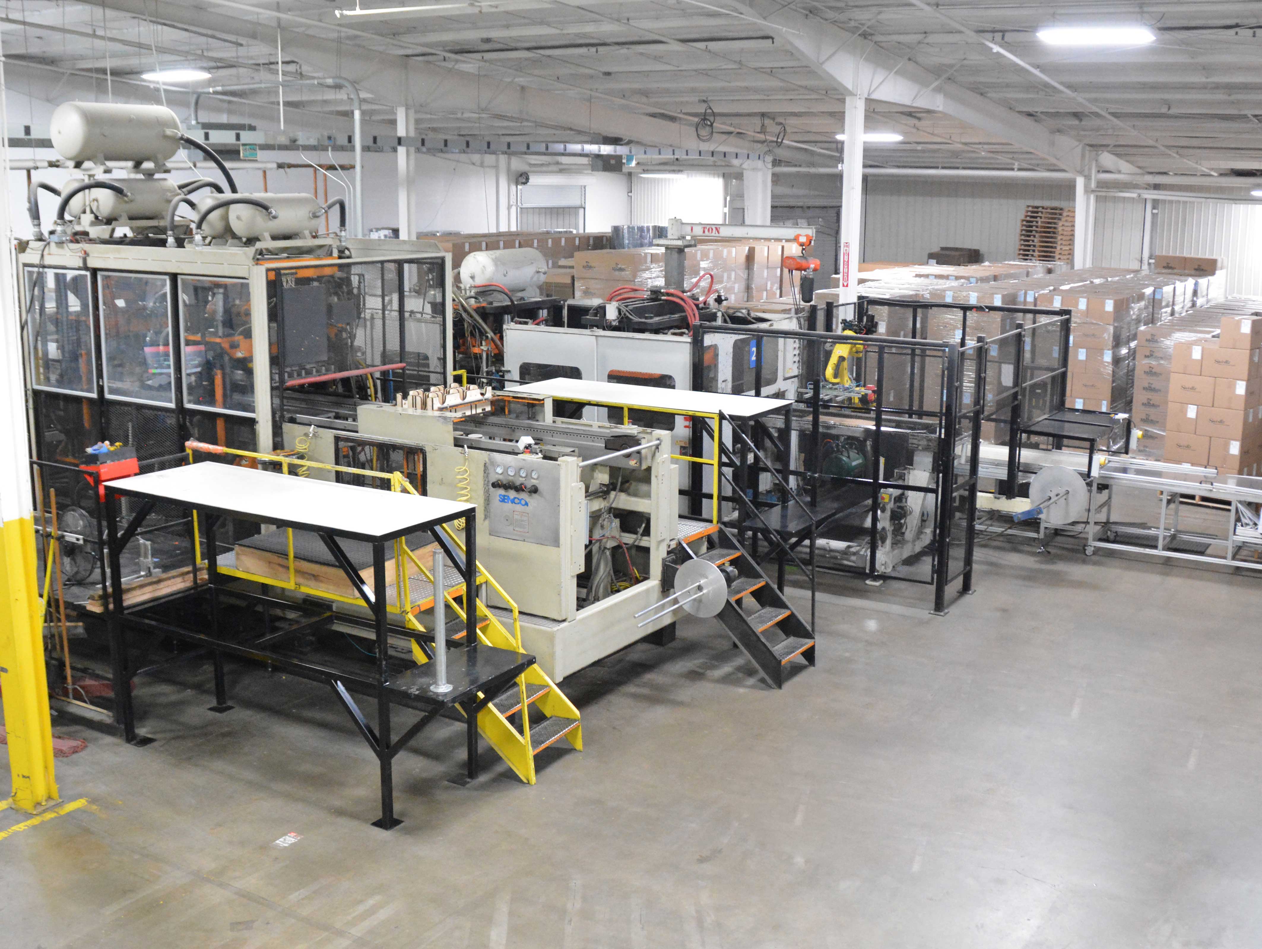 MinnTech Plastics thermoforming production floor with inline forming equipment and stacked packaging trays